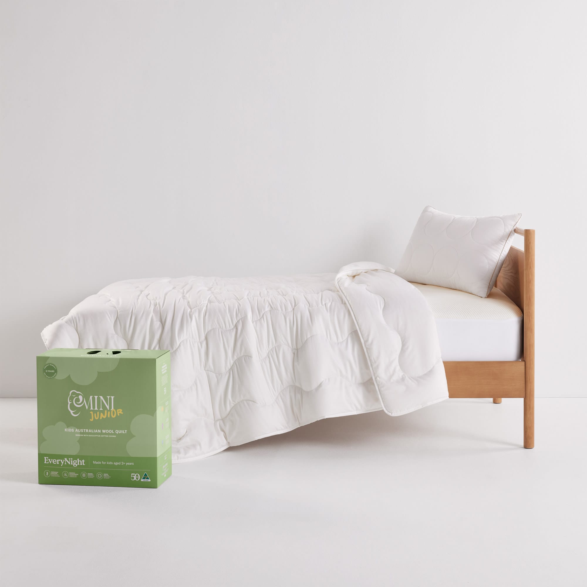 MiniJunior EveryNight Quilt on bed with box packaging - thumbnail #3